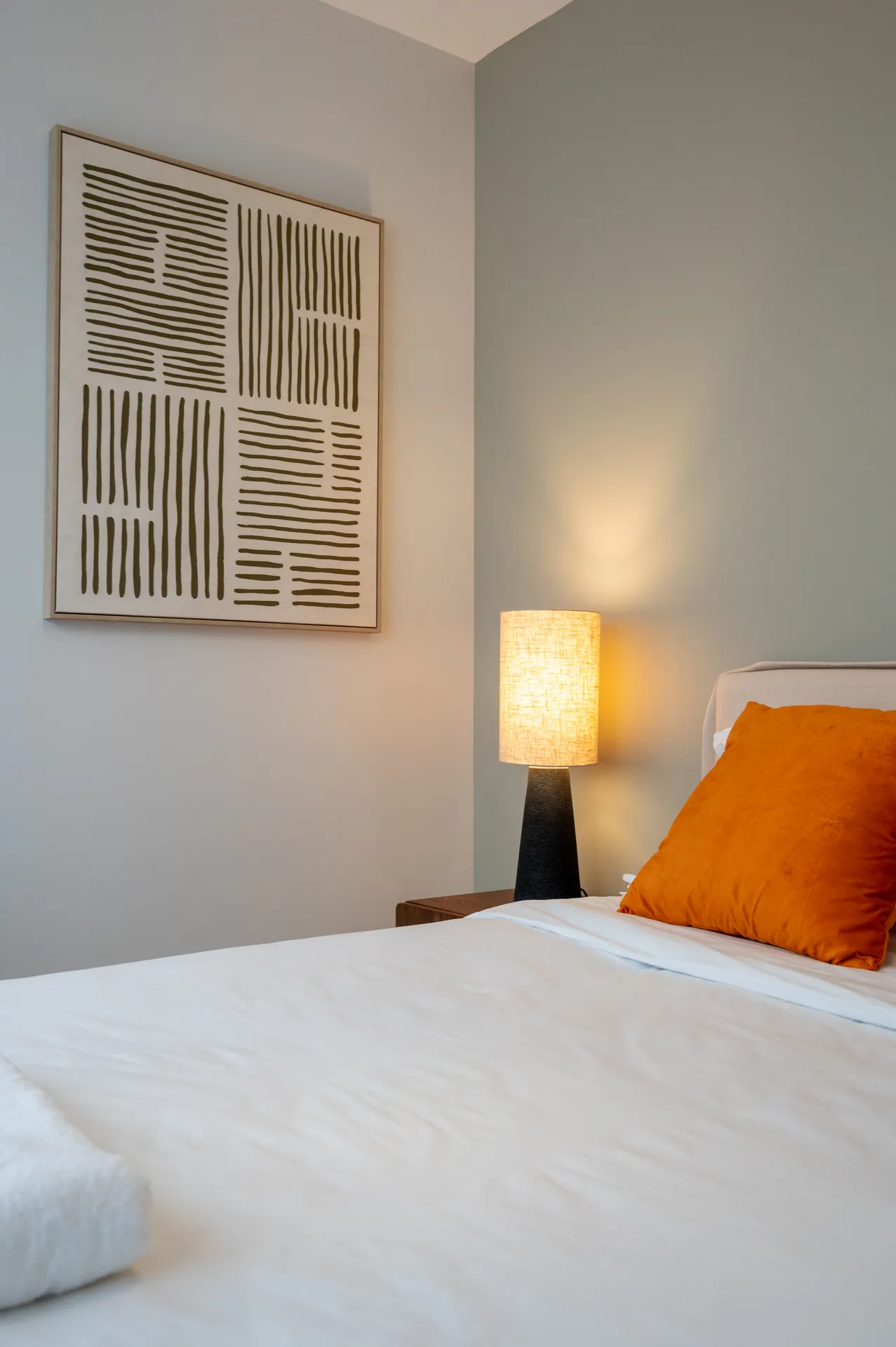Photo d'une chambre standard — chevet, lampe et affiche au mur
